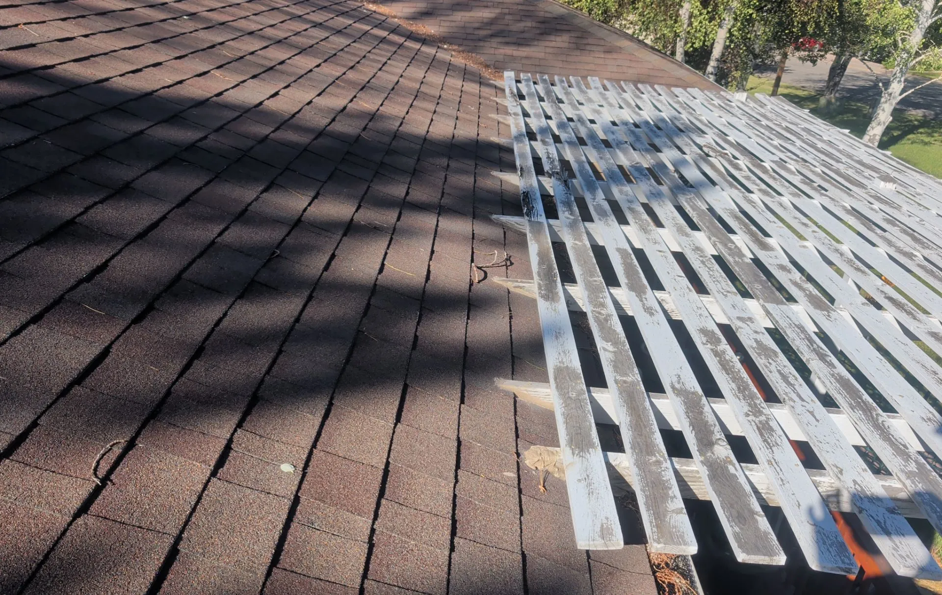 A roof mid-installation showing fresh synthetic underlayment and drip edge